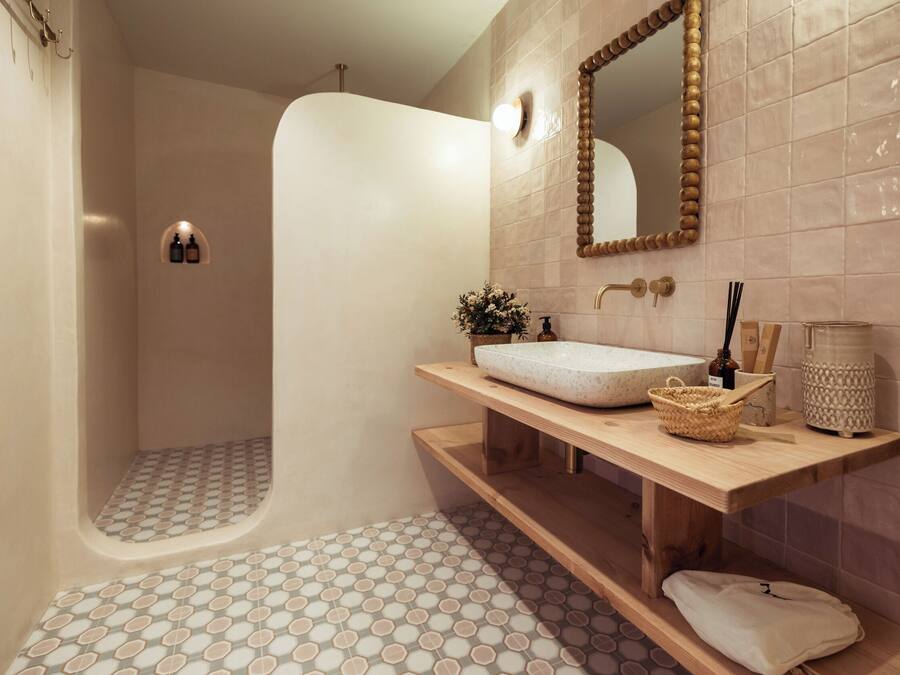 A modern bathroom with a freestanding bathtub, a wooden vanity with a sink, and a large mirror.