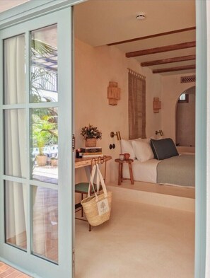 A bedroom with a bed, a desk with a chair, a small table with a cup, and a window with curtains. - Nomad Hotel & Spa Altea (Altea)
