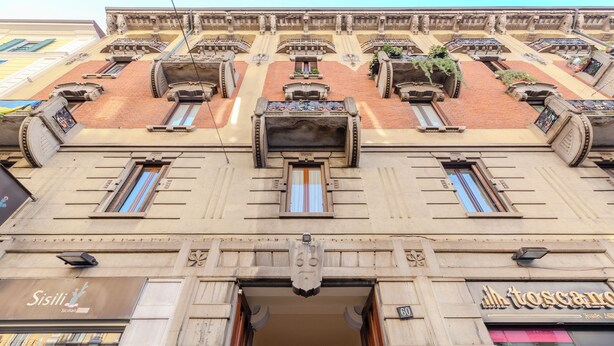 A building with ornate architectural details, including a central entrance with a decorative archway and multiple windows. - notaMi - Campus Bligny Bocconi District (Milan)