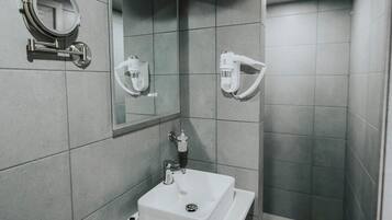 Ein modernes Badezimmer mit Waschbecken, Spiegel und Handtuchspender.