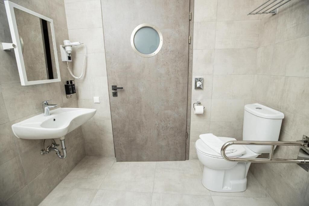 Een moderne badkamer met een wastafel, toilet en spiegel.