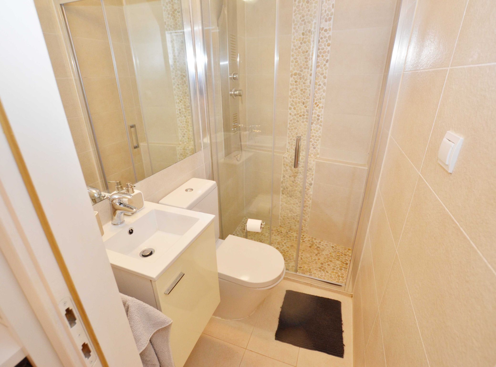 Ein Badezimmer mit Duschkabine, Waschbecken und Toilette.