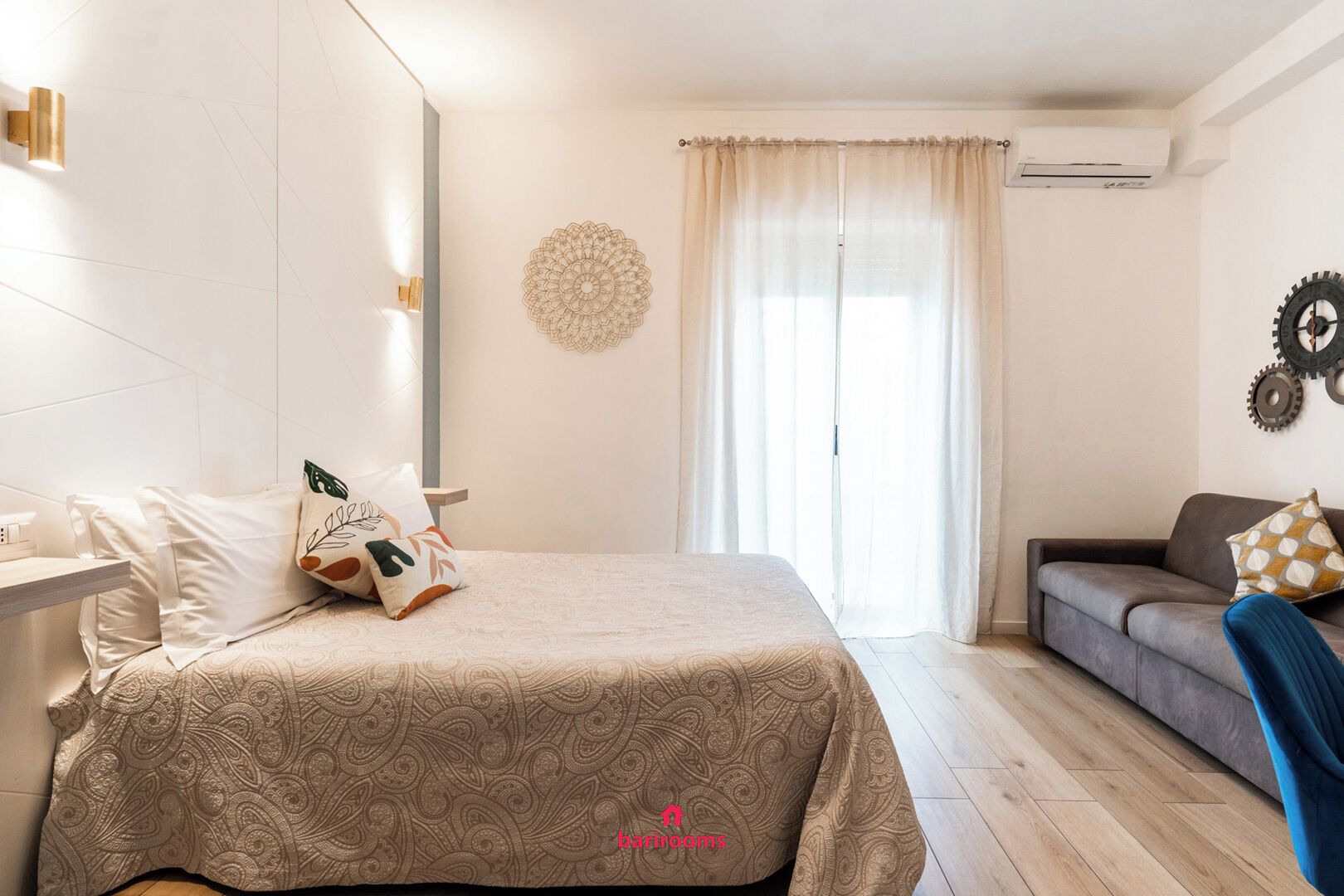 Une chambre à coucher moderne avec un lit, un canapé et un élément décoratif mural.