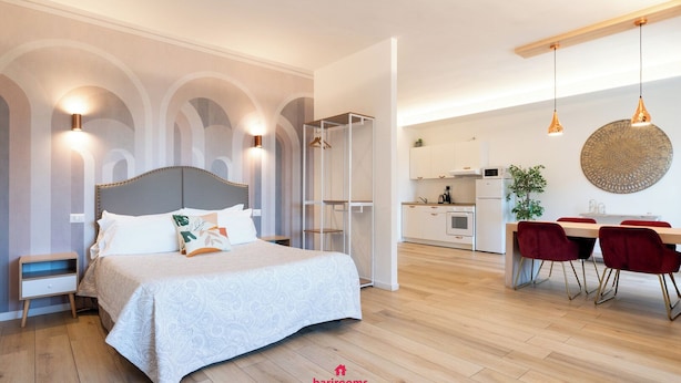Et moderne soveværelse med en stor seng, sengeborde og en indbygget garderobe.