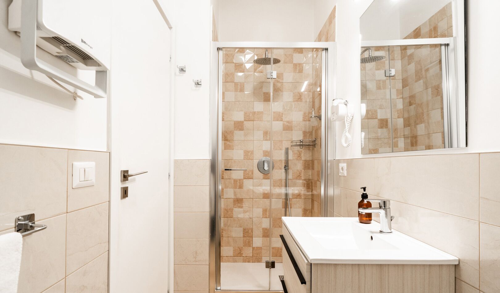 A modern bathroom with a glass shower enclosure, a white sink, and a mirror above the sink.
