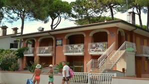 A building with multiple balconies and a staircase. - Comfy Beachside Vacation Home With Patio and Garden (Lignano Sabbiadoro)