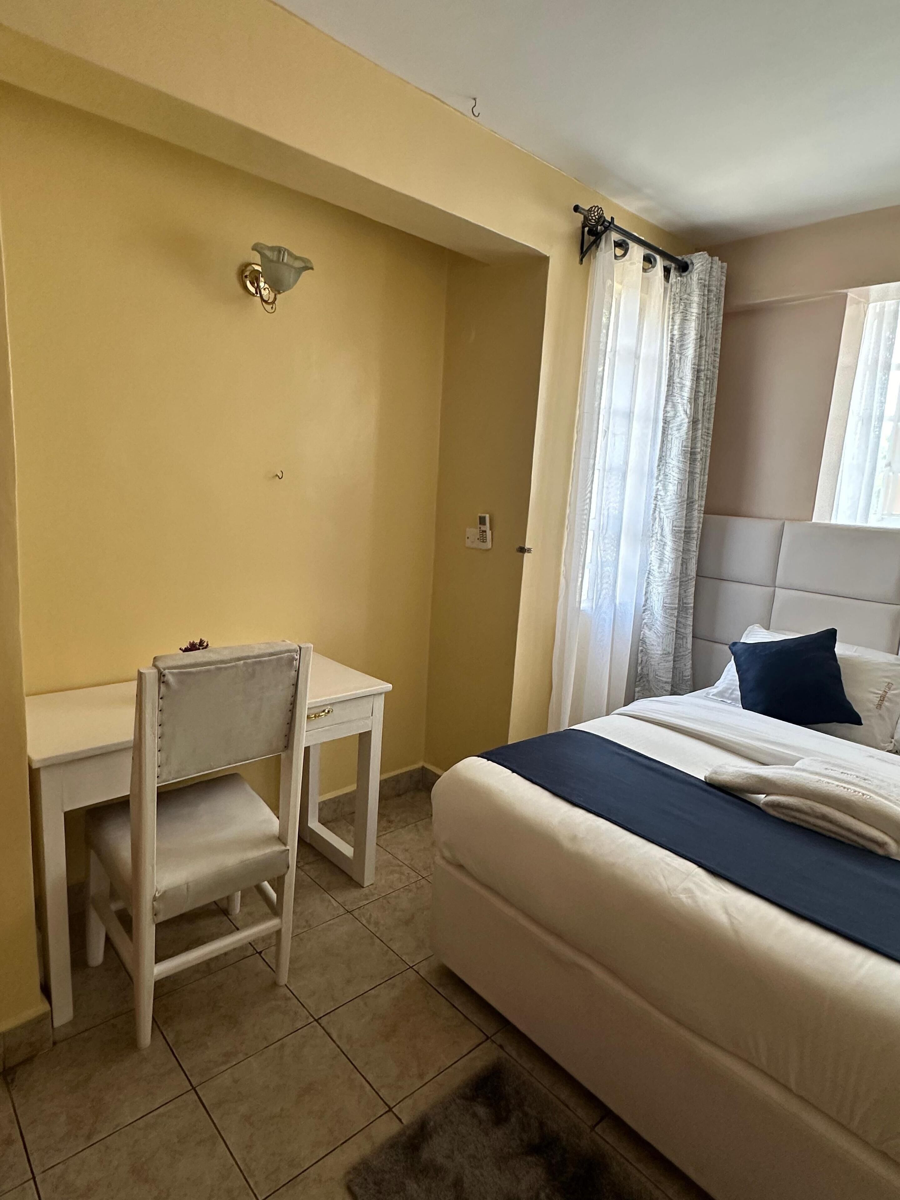 Un dormitorio con una cama, un escritorio y una silla.