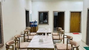 Una sala de conferències amb una taula llarga, diverses cadires i un sostre amb il·luminació empotrada.