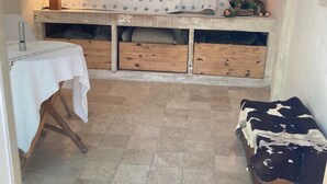 A small, cozy room with a bed, a bedside lamp, a table with a tablecloth, and a cowhide rug. - Terre libre 2, glamping. Hutt with garden and access to a river. (Fayence)