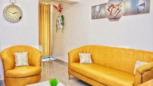 A living room with two mustard-colored sofas, a white coffee table, and a wall clock. - Comfort home! made life simple, Beautiful views and desirable lifestyle. (Nairobi)