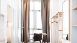 Une chambre avec un lit, un bureau, une chaise et une armoire.