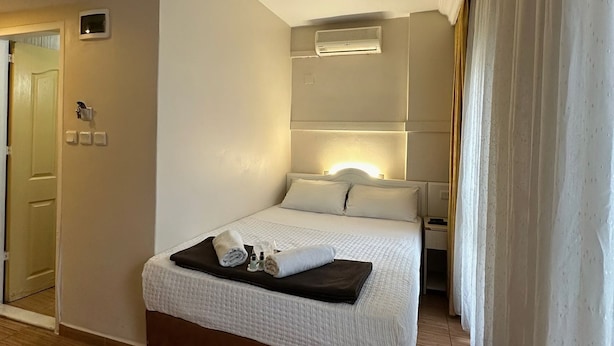 A hotel room with a bed, bedside table, and an air conditioning unit. - Hotel Büyük Şehzade (Istanbul)