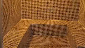 Una habitación con piso de baldosas, un banco y un escalón.
