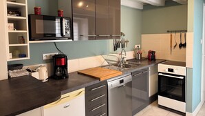 Een moderne keuken met een magnetron, koffiezetapparaat, vaatwasser en oven.