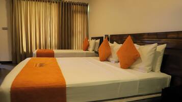 Habitación de hotel con dos camas, cada una con ropa blanca y detalles naranja, cabeceros de madera y un ventanal con cortinas.