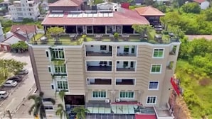 Un hôtel à plusieurs étages, doté d’un toit plat, de grandes fenêtres et d’un espace extérieur couvert.