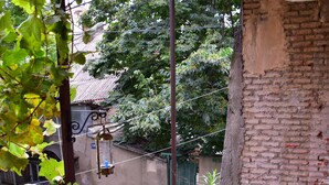 A balcony with a red floor, a blue railing, and a red stool. - The Librarians' Flat with Balcony (Tbilisi)