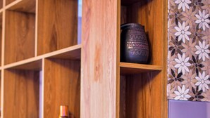 A wooden bookshelf with various items including books, a vase, and a potted plant. - The Librarians' Flat with Balcony (Tbilisi)