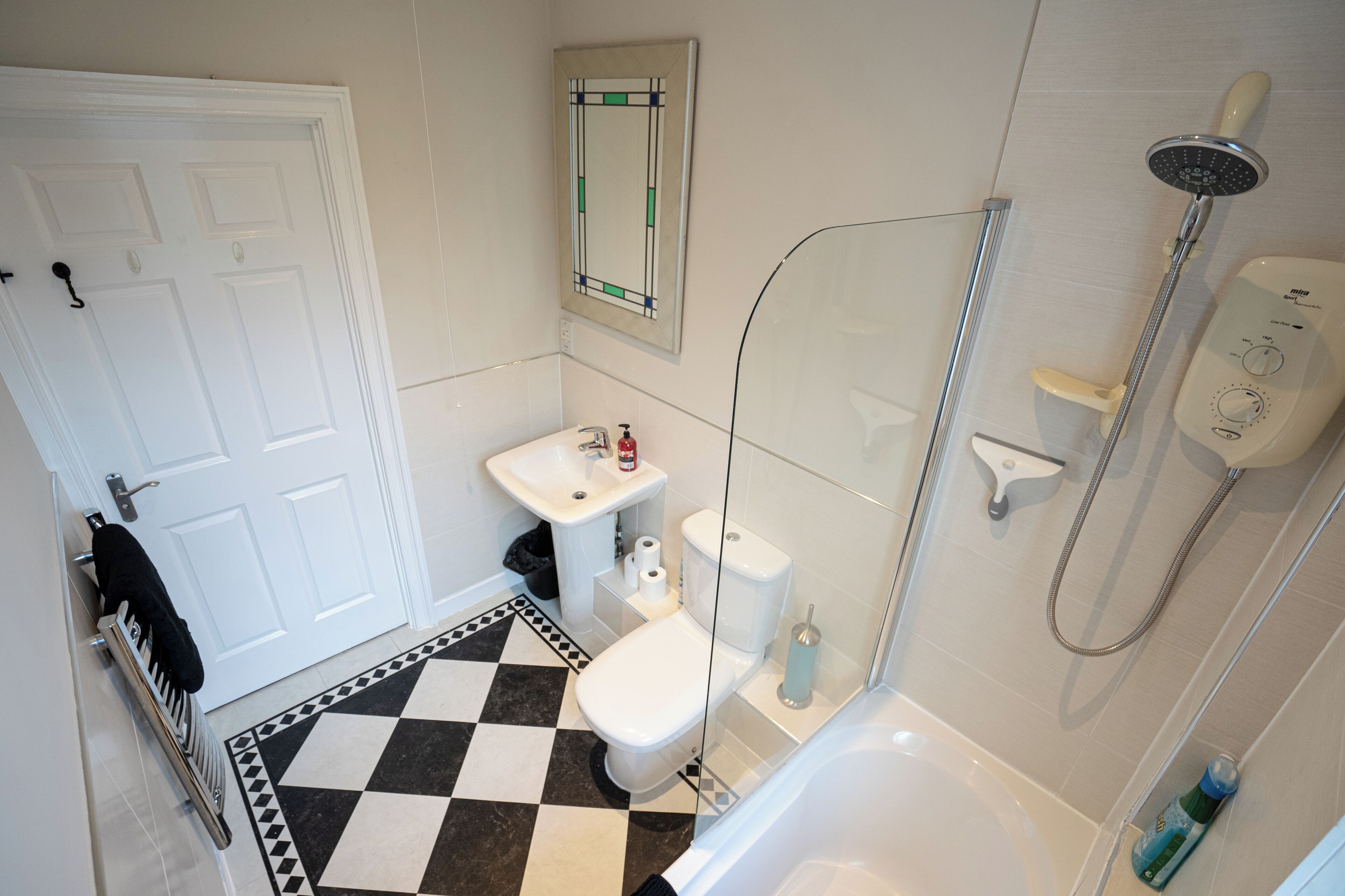Un bagno con il water, lavandino e doccia.