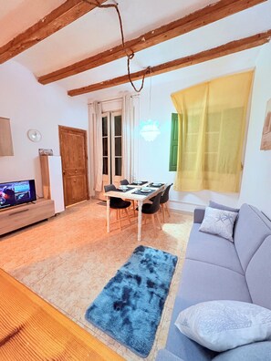 Relax in this inviting living space with a sofa, TV, and dining area.