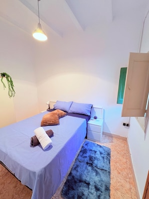 Cozy retreat with a single bed, nightstand, and pendant light.