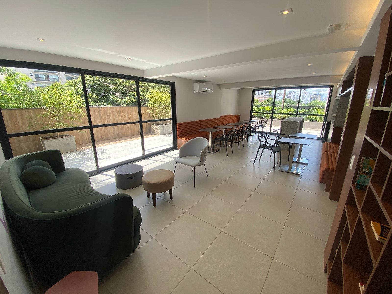 Een modern interieur met een bank, stoelen, een eethoek en grote ramen met uitzicht op het omliggende landschap.
