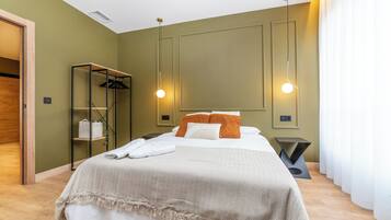 Una habitación de hotel con una cama, un armario y una mesita de noche.