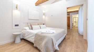 Camera moderna con un letto grande, un comodino e un punto luce a parete.