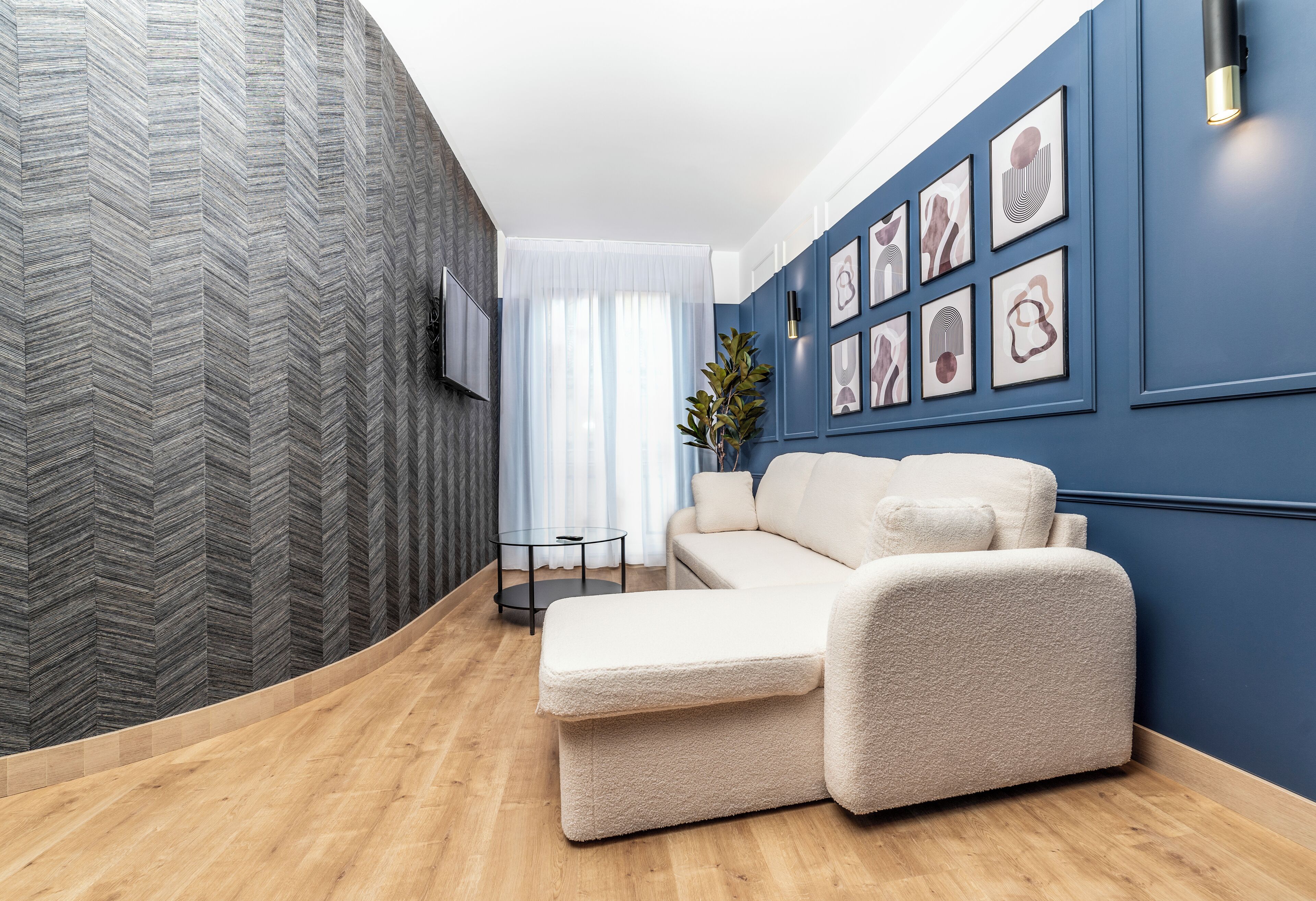 Una sala de estar moderna con un sofá, una mesa de centro y una planta decorativa.