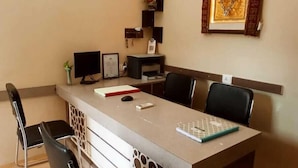 A modern office with a long table, black chairs, and a desk with a computer and printer. - Glow Inn HomeStay (Varanasi)