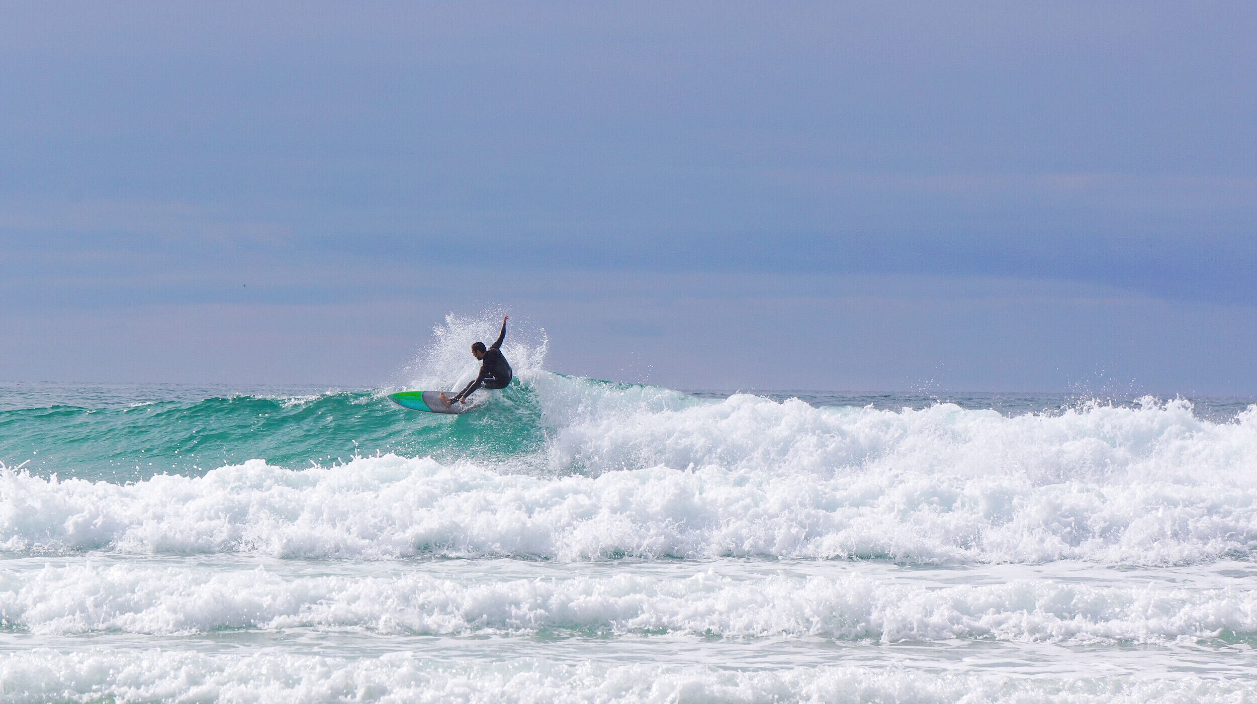 Um surfista deslizando numa onda.