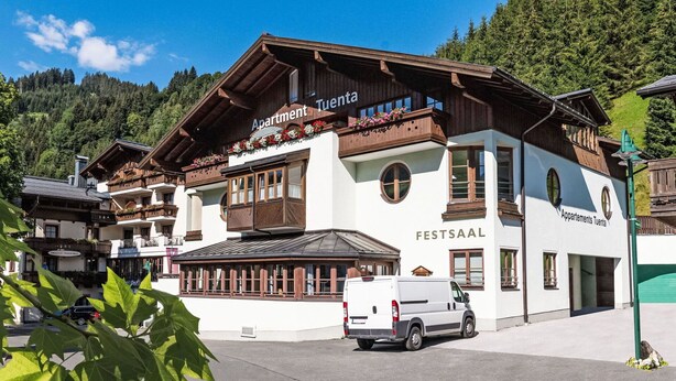 Ein traditionelles Gebäude im alpinen Stil mit einem Schild, auf dem 