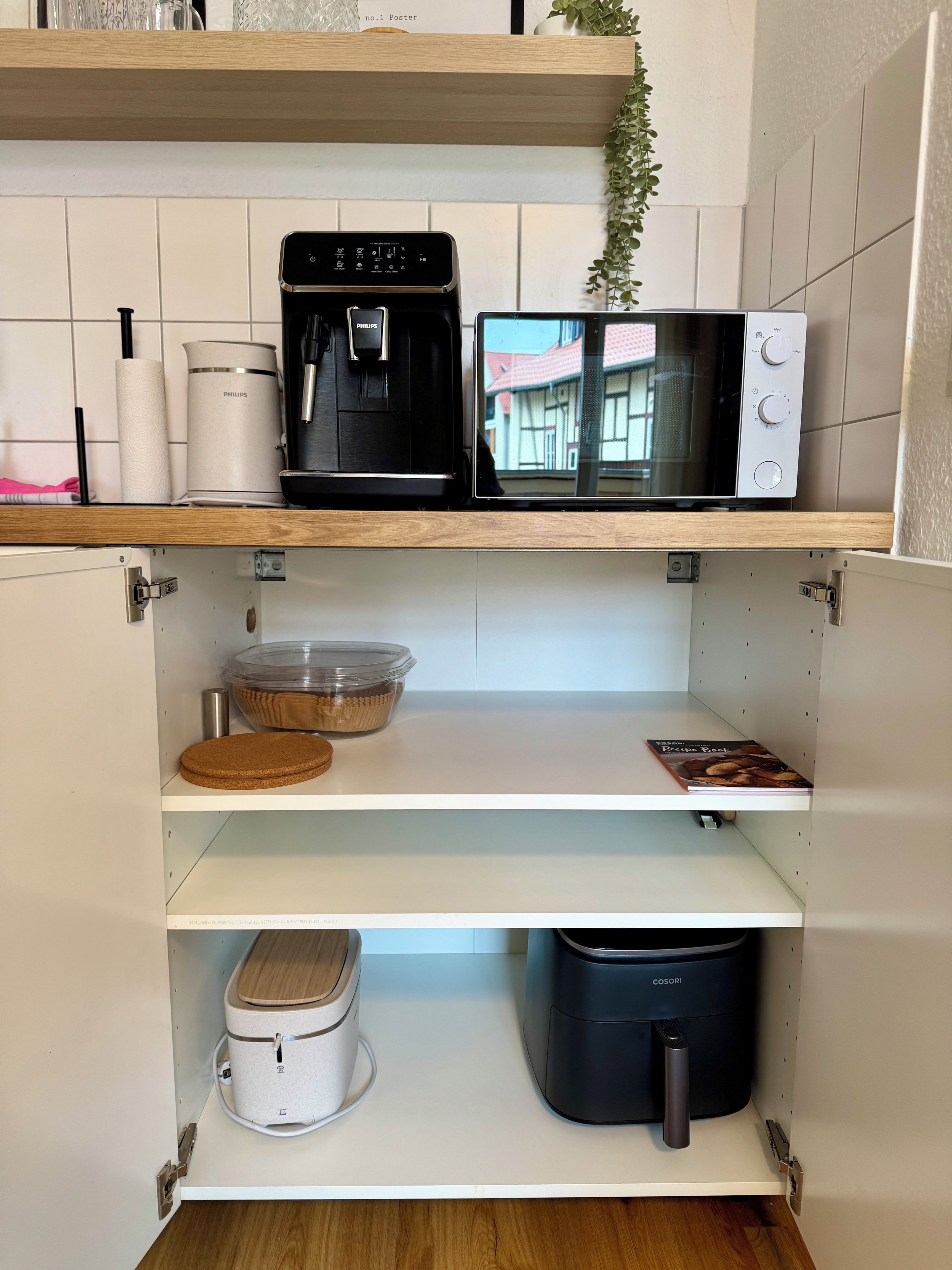 A kitchen with a coffee maker, microwave, and a book on the counter.