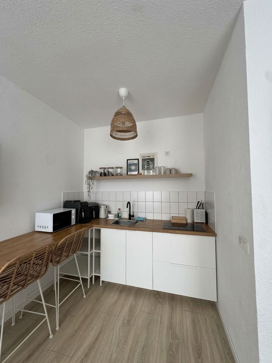 Cocina pequeña equipada con microondas, tostadora y lavabo.