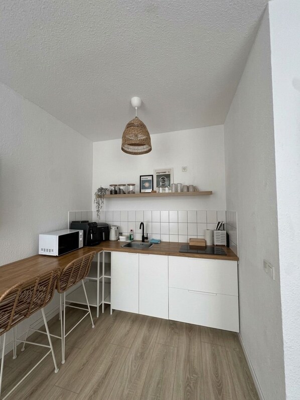 A compact kitchen with a microwave, toaster, and sink. - REGIOHOTEL am Nicolaiplatz Wernigerode (Wernigerode)