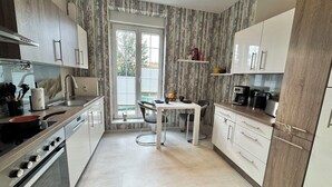 A modern kitchen with a dining area, large windows, and a view of the outdoors. - Nice apartment for 2 people with WIFI, hot tub, TV, patio and pets allowed (Steinheim)