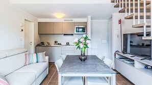 A modern apartment with a dining area, kitchen, and living space. - Lovely apartment for 4 guests with A/C, pool, WIFI, TV and balcony (Domaso)