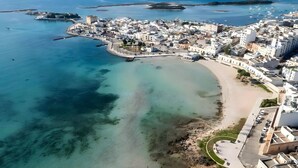 An aerial view of a coastal town with a beach, clear waters, and white buildings. - Casa Terrazza Sul Mare in Torre Lapillo (Torre Lapillo)