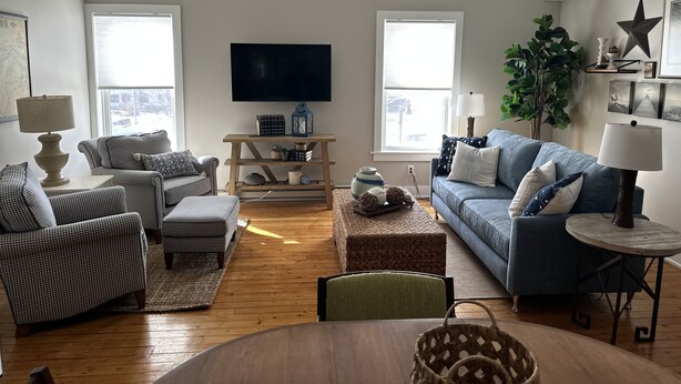 A living room with a sofa, chairs, a TV, and a coffee table.