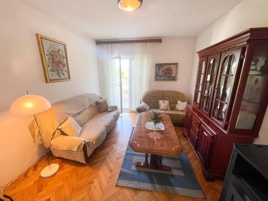 A living room with a sofa, a coffee table, a cabinet, and a lamp.
