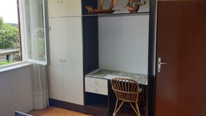 Un bureau équipé d’un pupitre, d’une chaise et d’une fenêtre donnant sur un espace verdoyant.