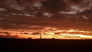 A sunset with clouds over a flat landscape.