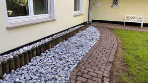 A pathway leading to a building with a white exterior and a bench in the yard. - Vacation apartment "Twistesee" at the Edersee (Waldeck)