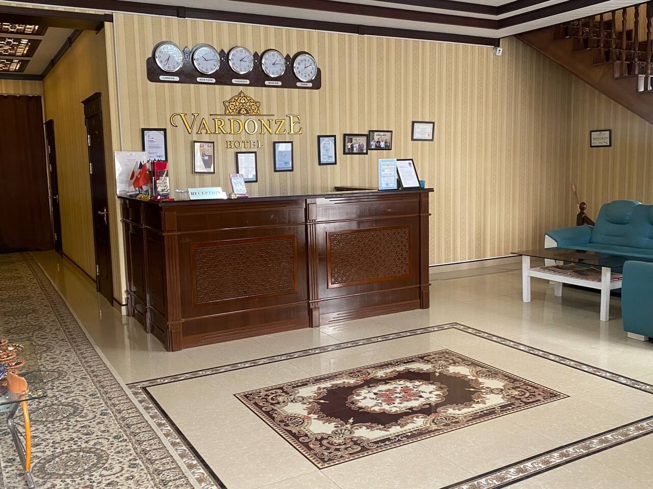 A reception desk with clocks, framed certificates, and a carpeted floor.