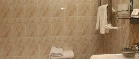 A bathroom with a bathtub, a sink, and a towel rack.