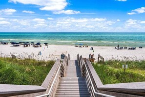 A wooden boardwalk leading to a beach with umbrellas and lounge chairs. - Experience luxury at Stepping Stone Main and Carriage House in Inlet Beach, perfect for 14! (Inlet Beach)