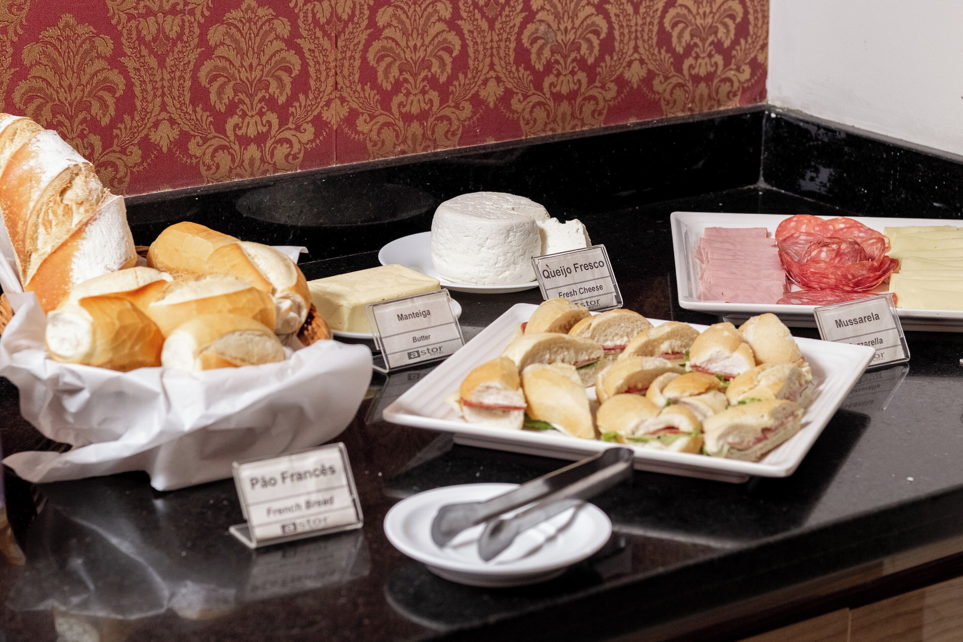 Ein Buffet mit verschiedenen Speisen, darunter Brot, Käse und Sandwiches.