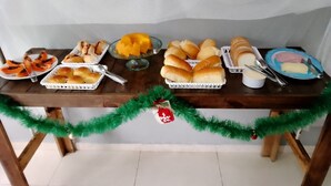 Ein reichhaltiges Buffet mit verschiedenen Speisen, darunter Brötchen, Gebäck und eine Schüssel mit gelber Creme.