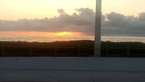 Ein Sonnenuntergang über einem Gewässer mit einem Zaun im Vordergrund.