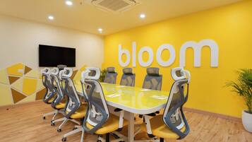 A conference room with a yellow wall, a large table, and six chairs.